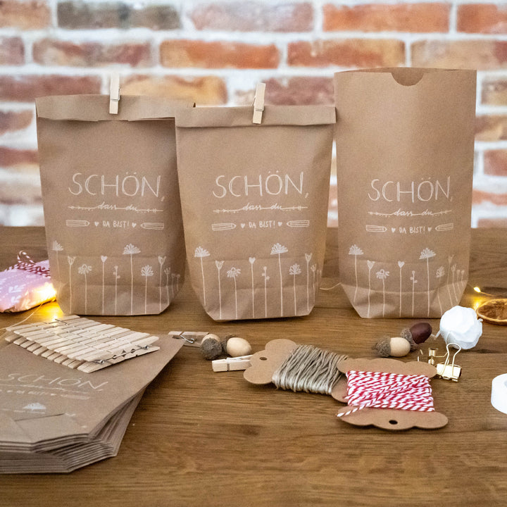24 Geschenktüten - Schön dass du da bist | für Gastgeschenke zur Hochzeit, Taufe, Konfirmation & Kommunion | 14 cm x 22 cm | inkl. 24 FSC Holz Miniklammern