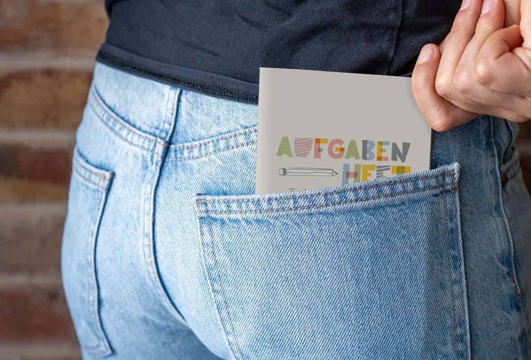 Hausaufgabenheft A6 steckt in der Gesäßtasche einer Jeans und passt in die Hosentasche