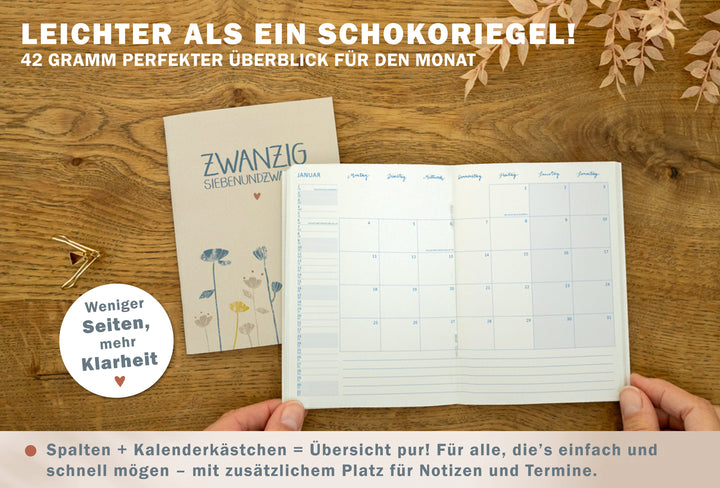 Geöffneter A6 Jahresplaner 2027 in Creme mit Monatsübersicht im Spalten- und Kästchenlayout und Notizbereich