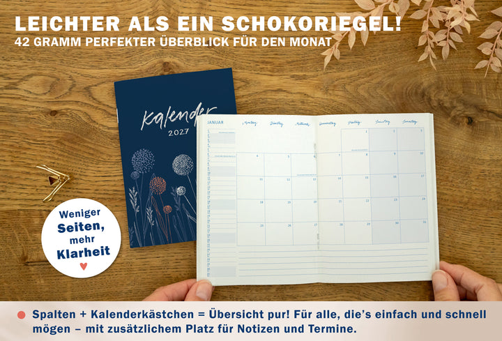 Geöffneter A6 Jahresplaner 2027 in Blau mit Monatsübersicht, Spalten- und Kästchenlayout sowie zusätzlichem Notizbereich für Termine.