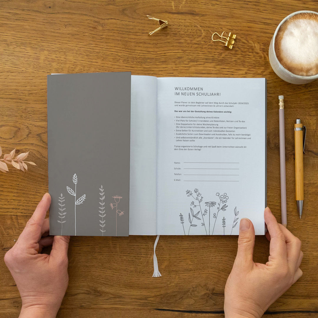 Innencover/Willkommensseite „Willkommen im neuen Schuljahr!“ mit Text und Eintragfeldern (Name, Schule, Telefon, E-Mail) sowie Zeichnung unten; Leseband sichtbar; nachhaltig auf FSC-Papier klimaneutral gedruckt, Klappe