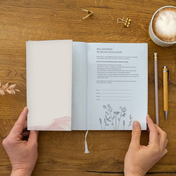 Innencover/Willkommensseite „Willkommen im neuen Schuljahr!“ mit Text und Eintragfeldern (Name, Schule, Telefon, E-Mail) sowie Zeichnung unten; Leseband sichtbar; nachhaltig auf FSC-Papier klimaneutral gedruckt, Einklappseite